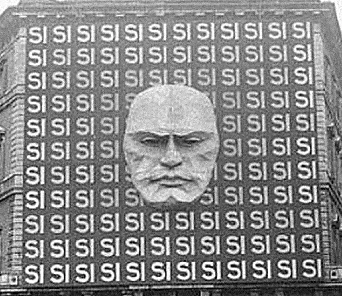 Fachada do Palazzo Braschi, em Roma, em 1934, coberta pela palavra SÌ repetida, com um enorme rosto de Mussolini ao centro.